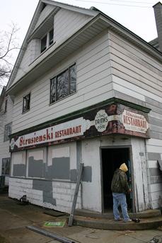 March 31, 2011: Work begins. Boarded up broken windows & doors are being replaced. Note 2nd floor windows.