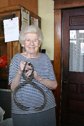 Corner store owner holds a pair of ice tongs that were used to fill the ice box on left.