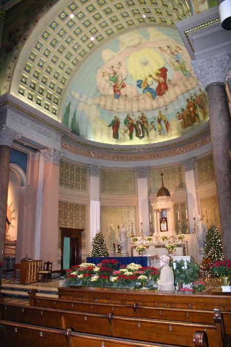 The interior, with its twelve monolithic granite columns, contains fifteen murals depicting the fifteen mysteries of the rosary lining the clerestory of the nave . The arcade of the nave is ringed with twenty-six rondos depicting the Popes and twenty-eight depicting the Blessed Virgin. A coffered ceiling frames the semidome of the apse which features a fresco of The Coronation