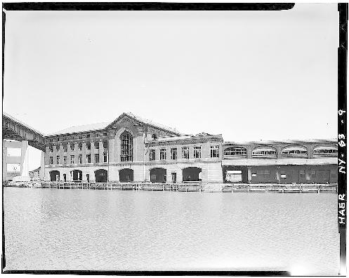View of DL&W complex from across Buffalo River. Two passenger buildings are at center, with train shed extending toward right. Skyway shows at top left, with Naval Park construction below.