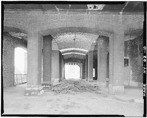 View of DL&W toward eastern end of property from South Park Avenue showing concrete access ramp to second level. Signal tower and smoke stack portions of Boiler Room structure are at left, and towers of Michigan Avenue Bridge over the Buffalo River are in background of photo.
