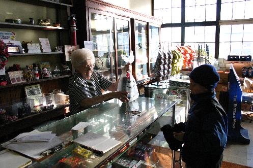In a scene repeated thousands of time over the decades, a young neighborhood customer counts out his change to purchase Pepsi. A candy bar bonus from the owner is part of the attraction of corner delicatessen. 